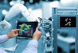 Industry 4.0 concept . Man hand holding tablet with performance check screen software and blue tone of automate wireless Robot arm in smart factory background